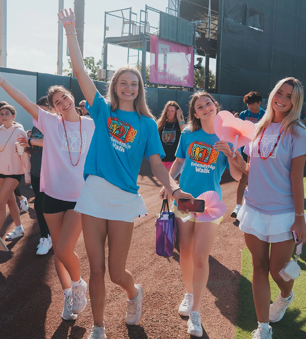 group of smiling participants with hands in the air